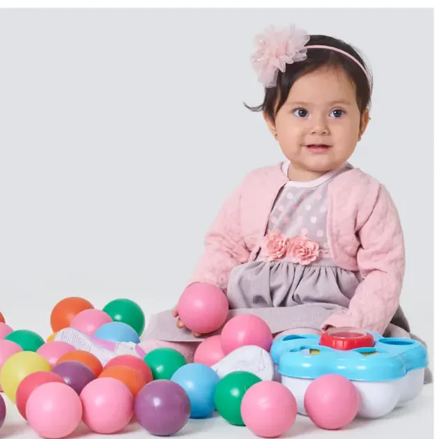 Niña rodeada de globos en su primer añito