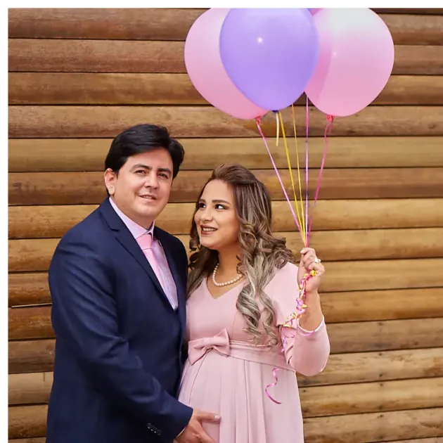 Pareja esperando bebé con globos de revelación