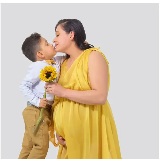 Niño besando la barriga de su mamá embarazada