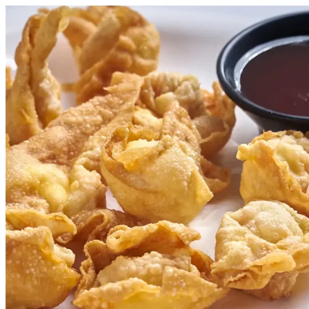 Wantanes fritos con salsa, comida china